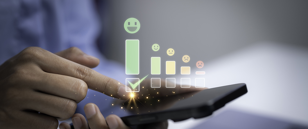 Engagement Scoring | Evok Advertising Hand holding a smartphone with holographic feedback icons and a green checkmark selected