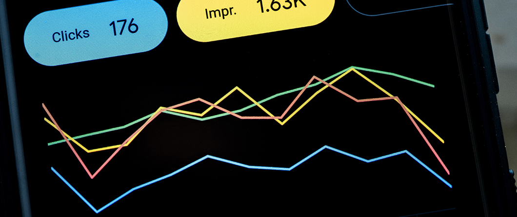 Local SEO Reputation and AI Search Visibility | Evok Advertising Smartphone screen showing a four line analytics chart with blue pink yellow and green lines and badges'Clicks 176' and 'Impr. 1.63K'.